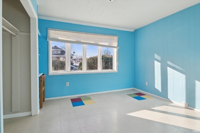 interior space featuring baseboards, visible vents, and ornamental molding