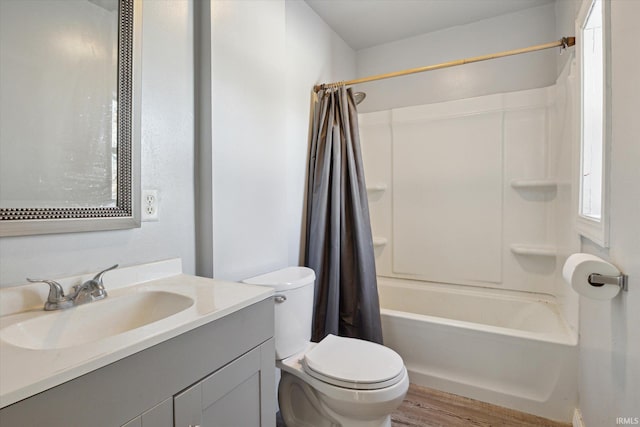 bathroom featuring wood finished floors, shower / bath combo with shower curtain, vanity, and toilet