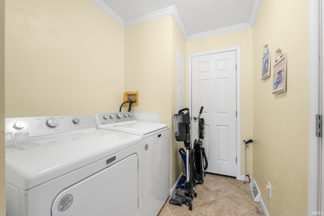 clothes washing area with laundry area, baseboards, washer and clothes dryer, and crown molding