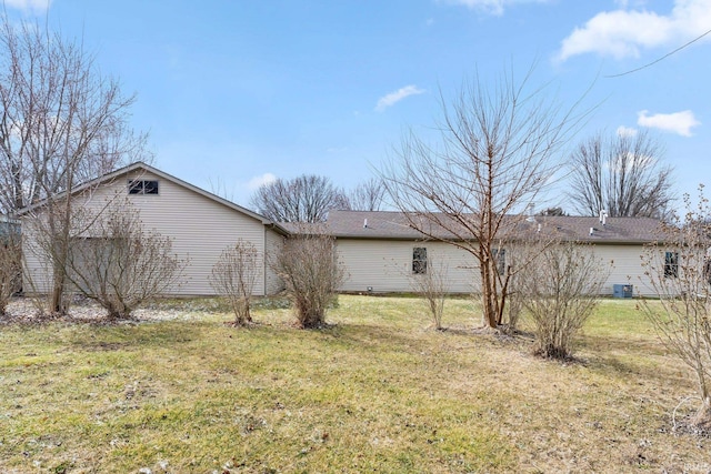 rear view of property featuring central AC and a yard