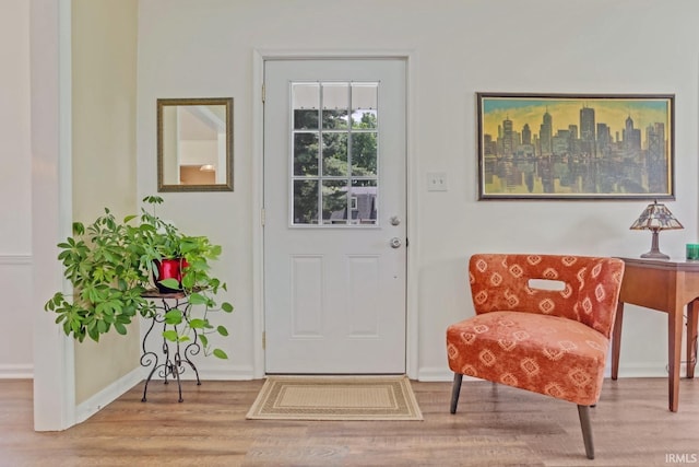 doorway featuring baseboards and wood finished floors