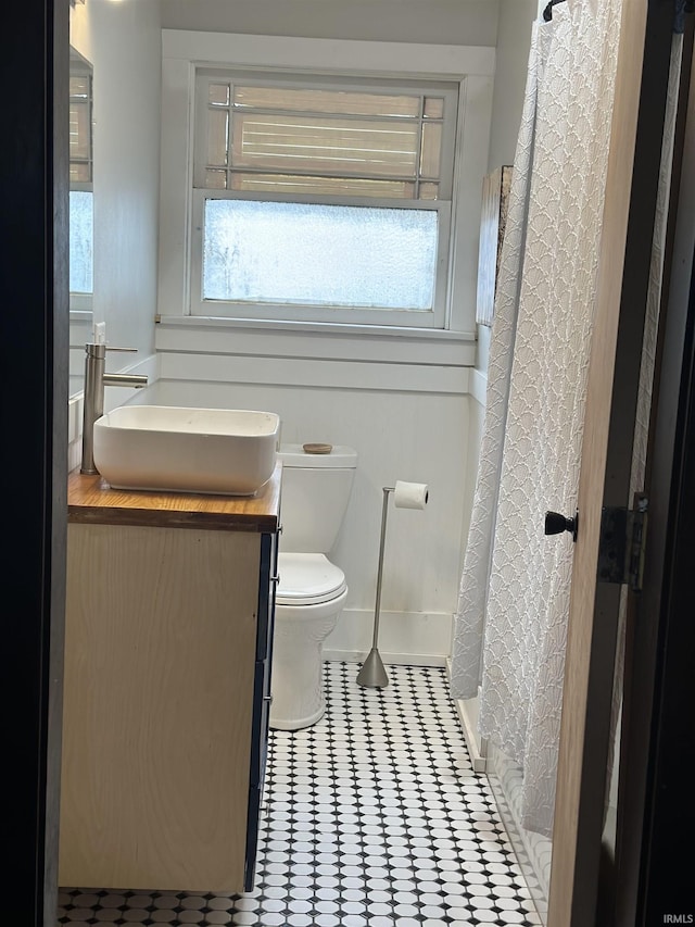 full bath featuring toilet, tile patterned flooring, a shower with shower curtain, and vanity