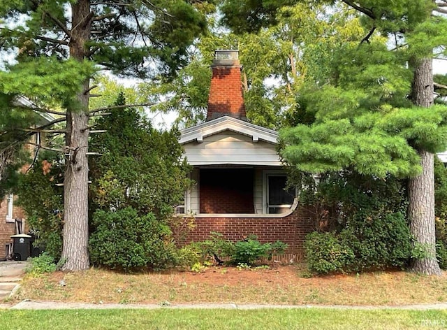 view of side of property with a chimney and brick siding