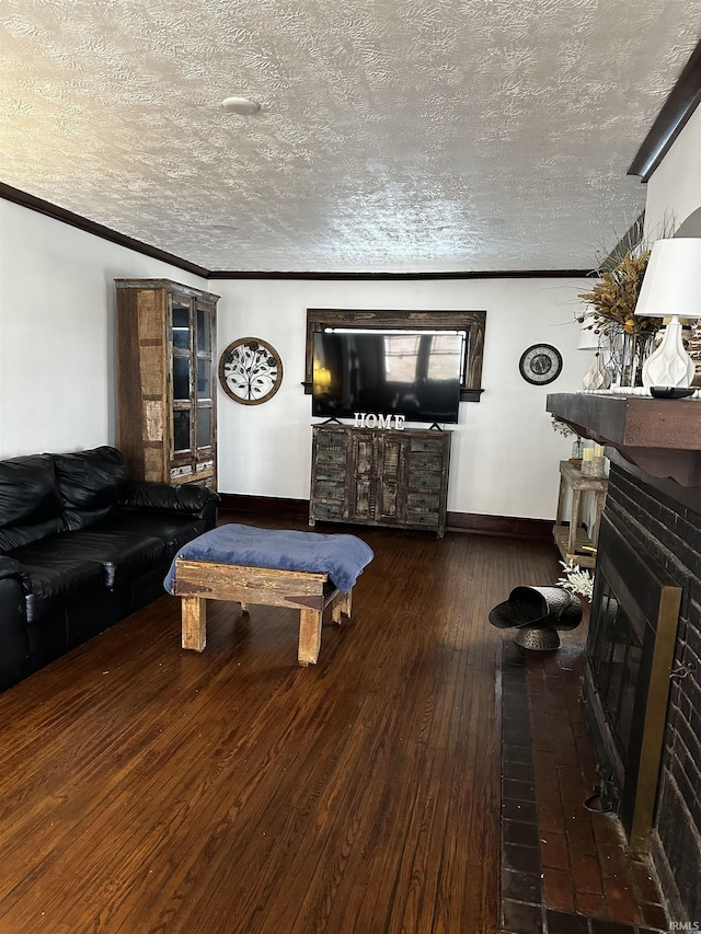 rec room with a brick fireplace, crown molding, wood-type flooring, and a textured ceiling