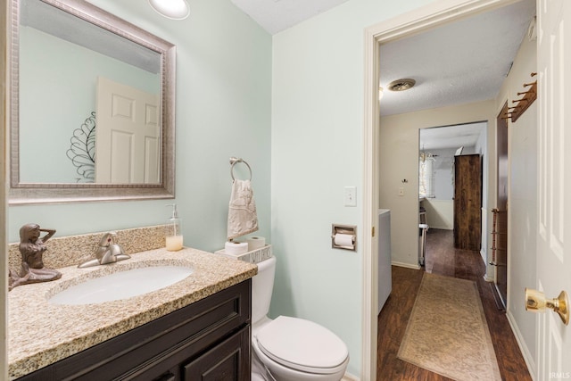 bathroom featuring toilet, wood finished floors, visible vents, vanity, and baseboards