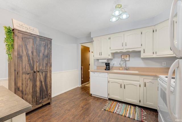 kitchen featuring white appliances, dark wood finished floors, light countertops, a textured ceiling, and a sink