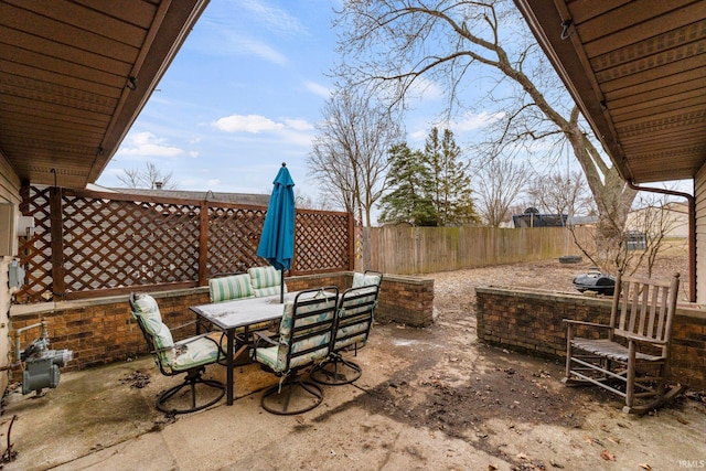 view of patio featuring outdoor dining area and fence