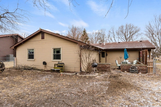 rear view of house featuring central AC and fence