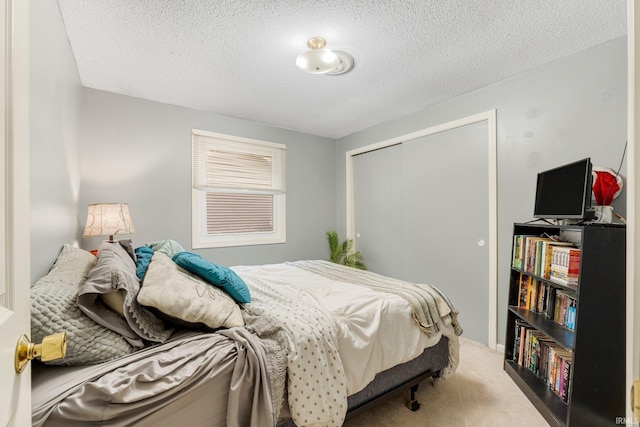 carpeted bedroom featuring a closet and a textured ceiling