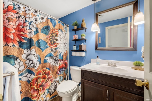 bathroom featuring toilet, curtained shower, and vanity