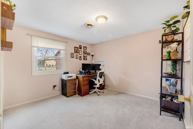 office featuring a textured ceiling, carpet flooring, and baseboards