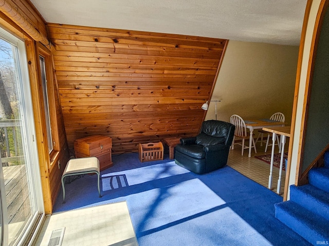 unfurnished room with wood walls, stairway, and visible vents