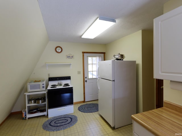 kitchen featuring light floors, light countertops, white cabinetry, a textured ceiling, and white appliances