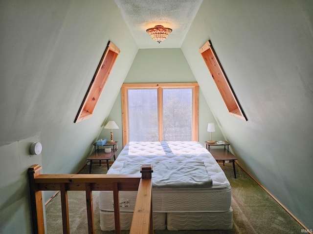 bedroom featuring lofted ceiling with skylight, carpet flooring, and a textured ceiling