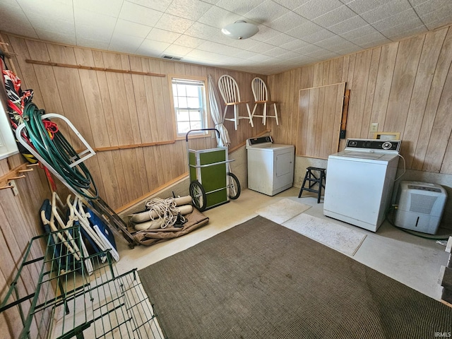 laundry area featuring laundry area, separate washer and dryer, visible vents, and wooden walls