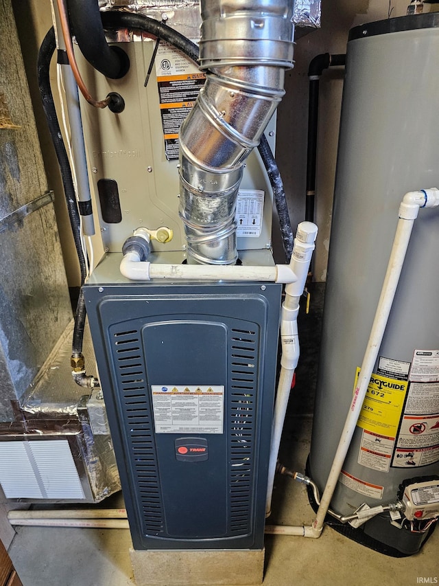 utility room featuring water heater and heating unit