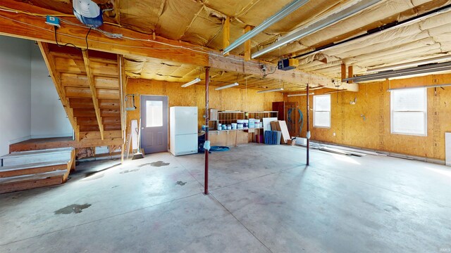 basement featuring a garage and freestanding refrigerator