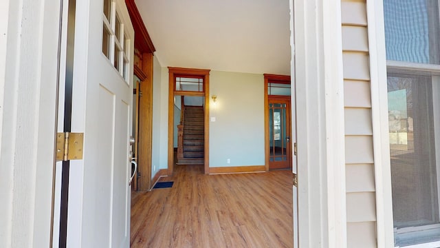 hallway featuring stairs, baseboards, and wood finished floors