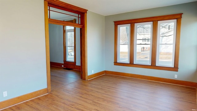 unfurnished room with light wood-style floors and baseboards