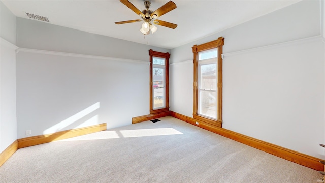 spare room featuring carpet, visible vents, and baseboards