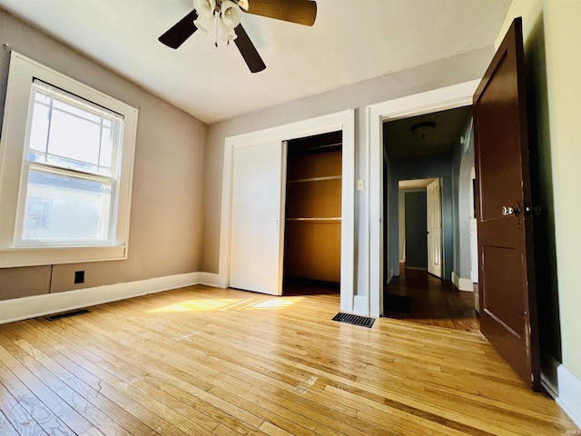 unfurnished bedroom with visible vents, a closet, light wood-style flooring, and baseboards