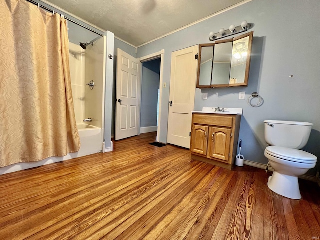 bathroom with shower / tub combo with curtain, toilet, vanity, wood finished floors, and baseboards