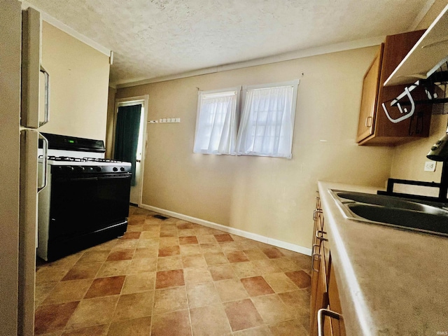 kitchen featuring visible vents, light countertops, black gas range oven, a textured ceiling, and baseboards