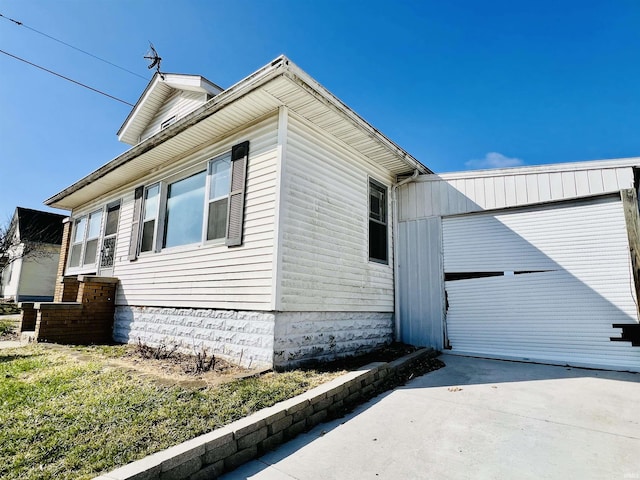 view of side of home with concrete driveway