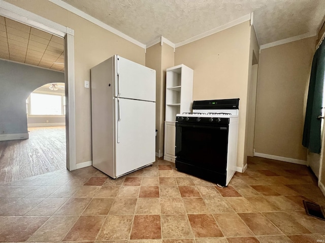 kitchen with arched walkways, black range with gas cooktop, baseboards, ornamental molding, and freestanding refrigerator