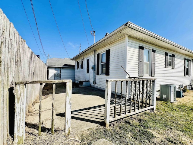 rear view of property with a patio area, fence, and cooling unit