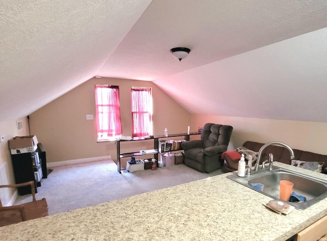 interior space featuring carpet floors, vaulted ceiling, a sink, a textured ceiling, and baseboards