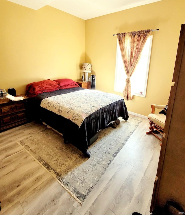 bedroom with baseboards and wood finished floors