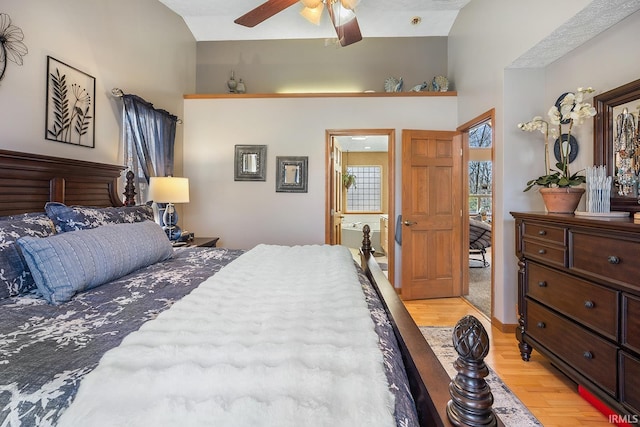 bedroom featuring a ceiling fan, light wood-type flooring, and lofted ceiling