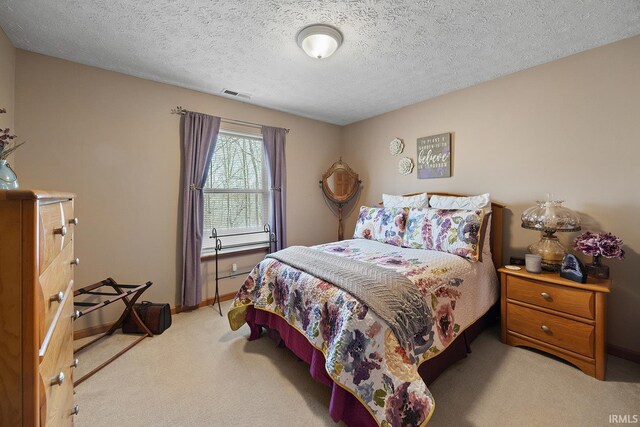 bedroom with light colored carpet, visible vents, a textured ceiling, and baseboards