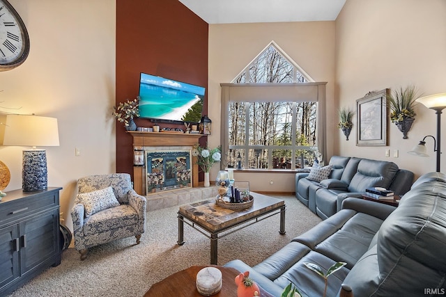 carpeted living area with a high ceiling and a fireplace