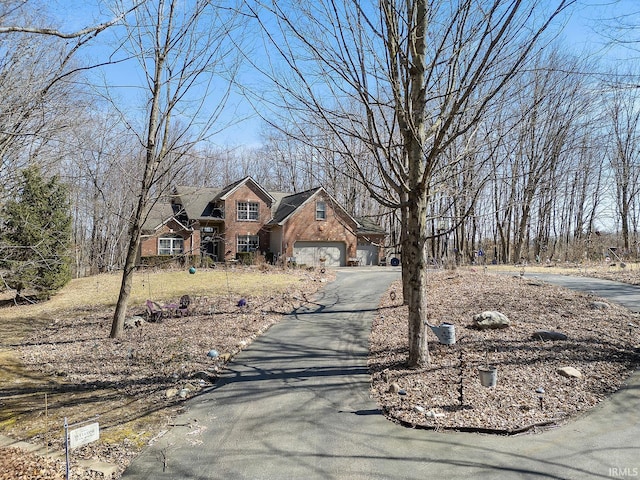 traditional-style home with aphalt driveway and brick siding