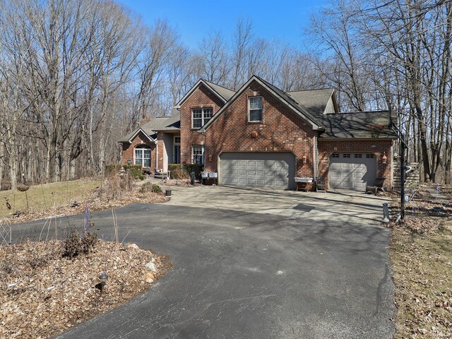 view of front facade with aphalt driveway, brick siding, and an attached garage