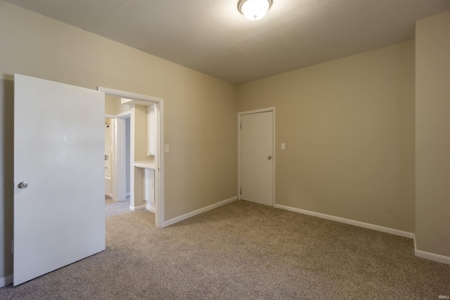 carpeted spare room featuring baseboards