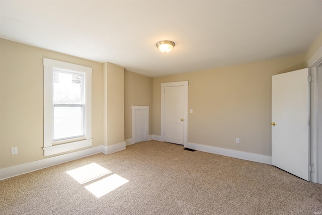 unfurnished bedroom featuring light carpet, visible vents, and baseboards