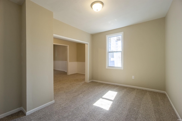 spare room with baseboards and carpet