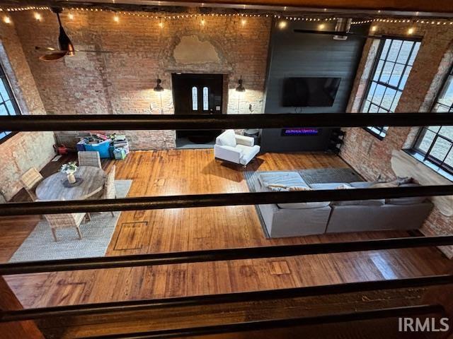 bar featuring wood finished floors and brick wall