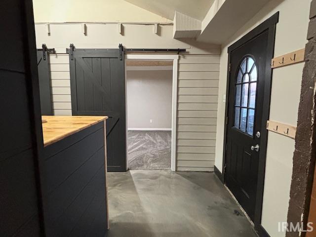 interior space featuring concrete flooring and a barn door