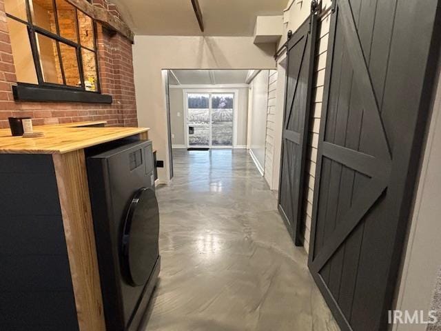 interior space with baseboards, laundry area, washer / clothes dryer, and a barn door