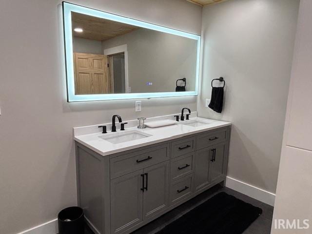 bathroom featuring a sink, baseboards, and double vanity