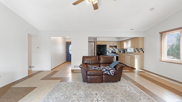 living area with lofted ceiling, baseboards, and light tile patterned floors