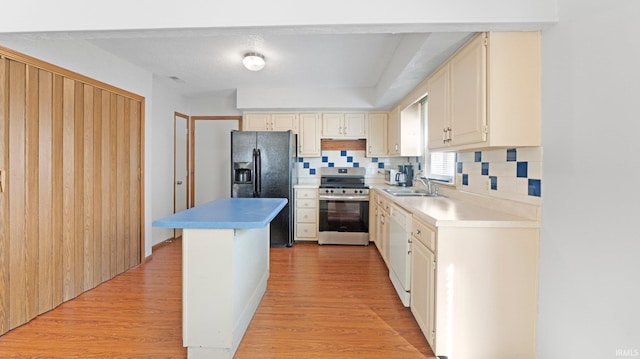 kitchen with light wood-style floors, black fridge, a sink, and stainless steel electric stove