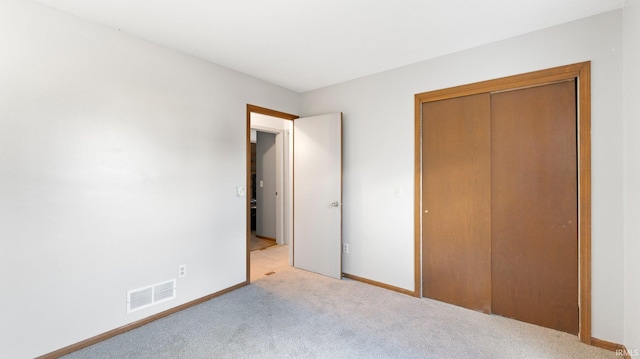 unfurnished bedroom with light carpet, baseboards, visible vents, and a closet