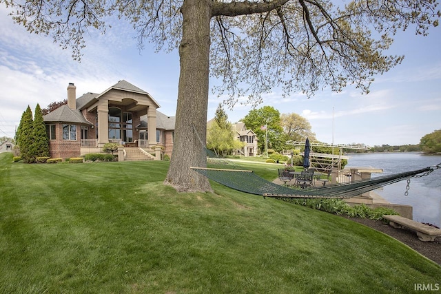 view of yard featuring a dock and a water view