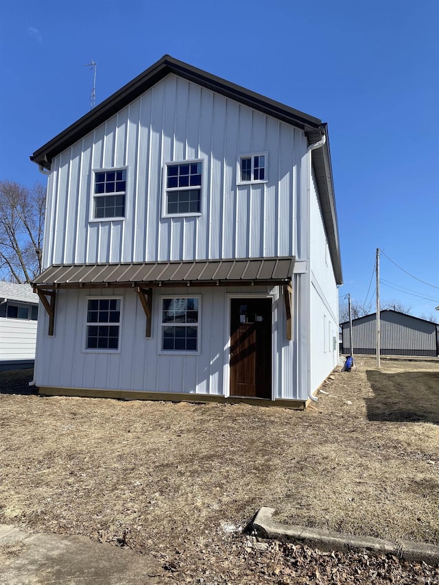 rear view of house featuring a standing seam roof, metal roof, and board and batten siding