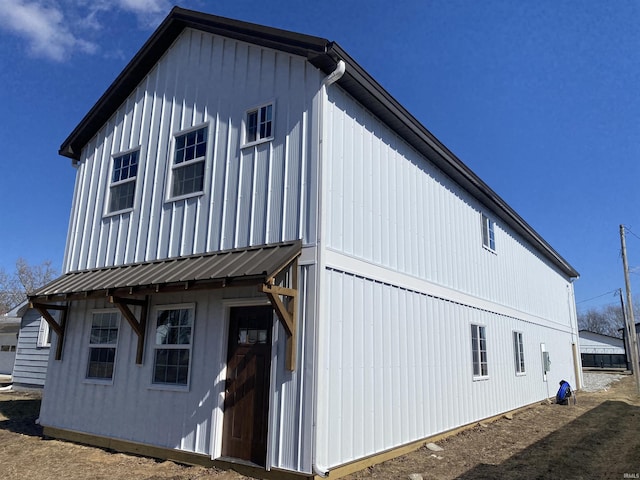 view of side of property featuring an outbuilding, metal roof, and board and batten siding